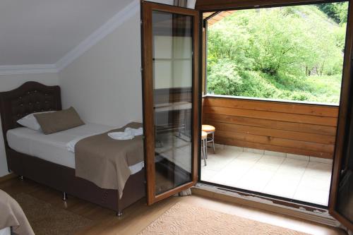 a bedroom with a bed and a large window at Uzungol Selale otel Bungalow in Uzungöl