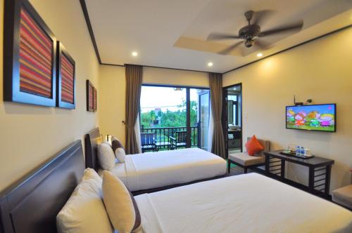 a hotel room with two beds and a television at The Quin Riverside Villa in Hoi An