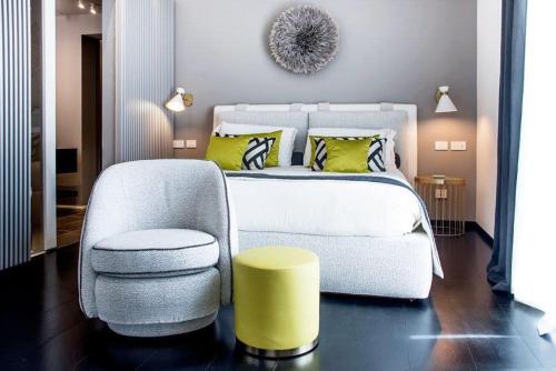 a bedroom with a white bed and a chair at Hotel Byron in Forte dei Marmi