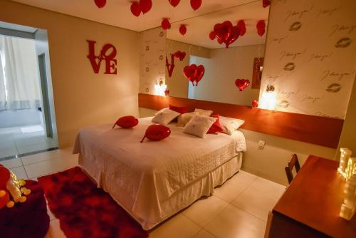 a bedroom with a bed with red hearts on the wall at Pianna Hotel in Buritis