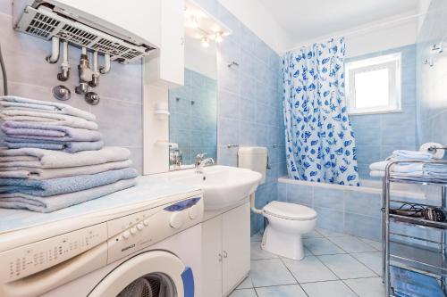 een blauwe badkamer met een wastafel en een toilet bij Apartments Gea in Mošćenička Draga