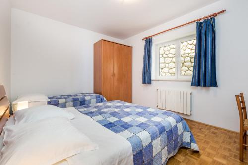 een slaapkamer met 2 bedden en een raam bij Apartments Gea in Mošćenička Draga