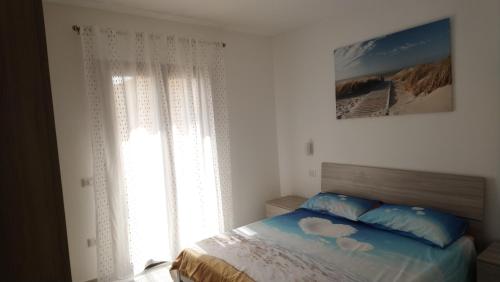 a bedroom with a bed and a window at Apartment Mistral in Badesi