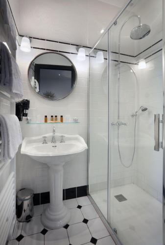 a bathroom with a sink and a glass shower at Château des Comtes de Challes in Challes-les-Eaux