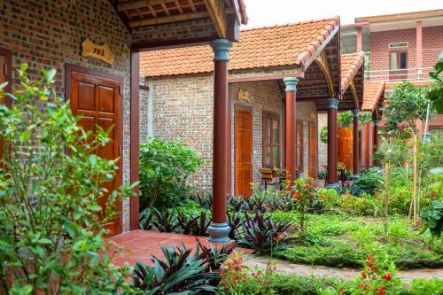 a brick house with a walkway in a garden at Ruby Homestay in Ninh Binh