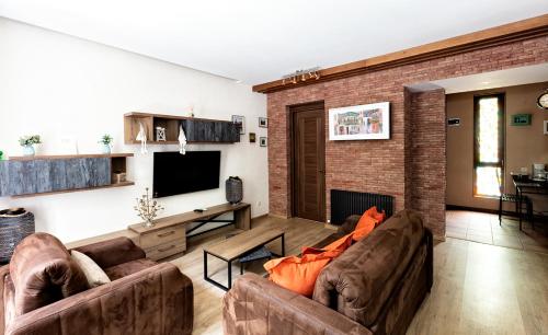 een woonkamer met twee banken en een tv bij Old Walls 1 in Tbilisi City