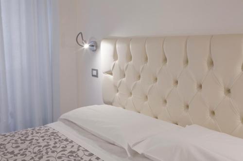 a bed with a white headboard in a bedroom at Appartamenti Museo in Verona