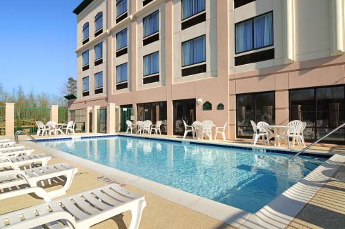 uma piscina do hotel com espreguiçadeiras e um edifício em Wingate by Wyndham LaGrange em La Grange