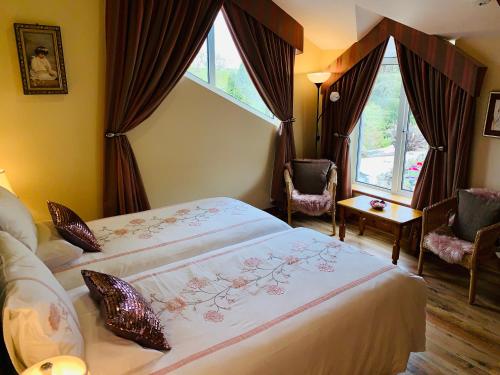 a hotel room with two beds and two windows at Wicklow Way Lodge in Wicklow