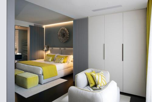 a bedroom with two beds and a chair at Hotel Byron in Forte dei Marmi