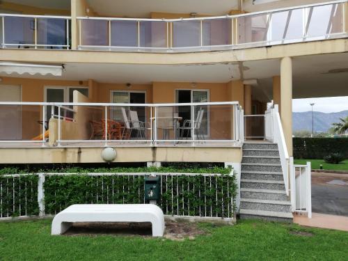 a building with a balcony and a table on the grass at Parquemar VIII Solo Familias Serviplaya in Xeraco