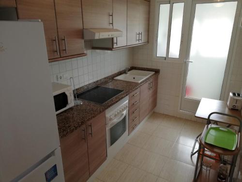 a small kitchen with a sink and a microwave at Parquemar VIII Solo Familias Serviplaya in Xeraco