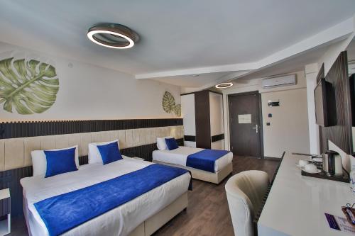 a hotel room with two beds and a desk at Kavala Hotel in Bursa