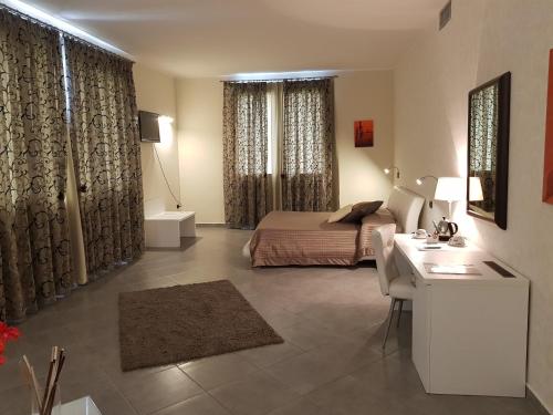 a hotel room with a bed and a desk and a desk at Hotel Saturday in Palma Campania