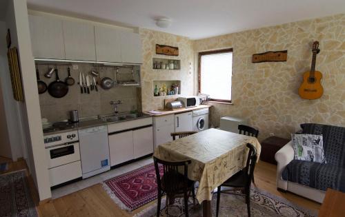 a kitchen with a table and a kitchen with a guitar on the wall at Nordwand Apartment in Tauplitz