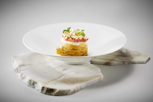 a cake on a plate on a piece of wood at Hotel Byron in Forte dei Marmi