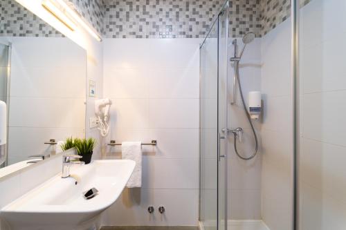 a bathroom with a sink and a shower at Hotel Centro Vitoria AutoCheckIn in Vitoria-Gasteiz