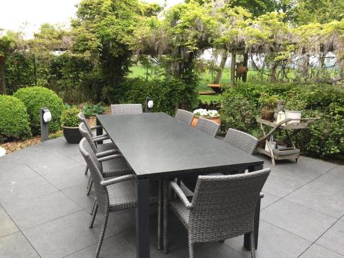 a black table and chairs on a patio at Gastenverblijf 't Hof van Eden in Wingene
