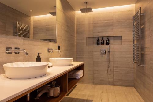 a bathroom with two sinks and a shower at ION Adventure Hotel, Nesjavellir, a Member of Design Hotels in Nesjavellir