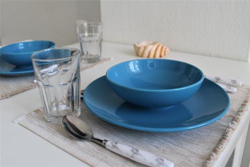 a table with two blue bowls and a glass at Dali Rooms in Chania Town