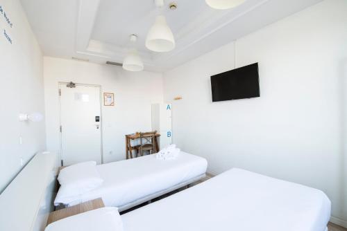 a hospital room with two beds and a tv at Safestay Madrid Central in Madrid