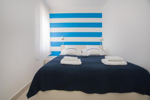 a blue and white bed with towels on it at blue adria in Primošten