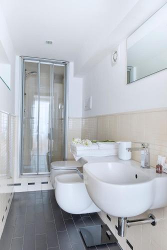 a white bathroom with two sinks and a toilet at Fiorentini Residence NAPOLI in Naples