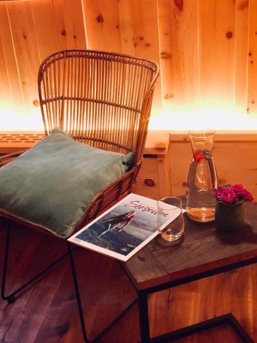 a chair and a table with a book on it at Landhaus am Stein in Bad Wiessee