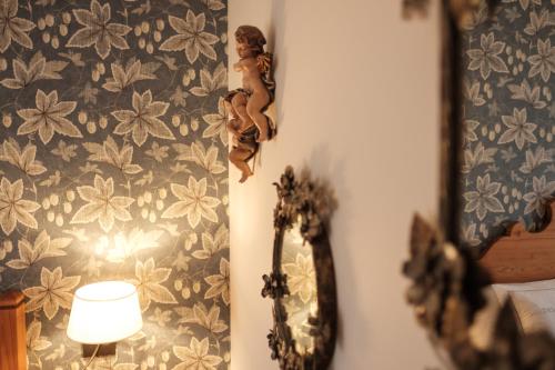 a mirror in a room with a flowery wallpaper at Landhaus am Stein in Bad Wiessee