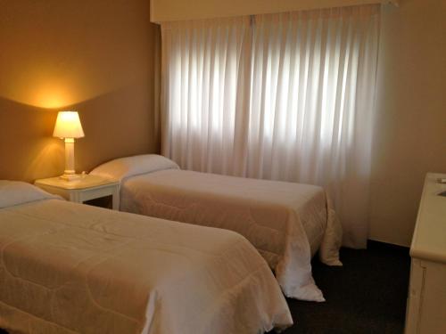 a hotel room with two beds and a window at Hotel Castilla in Punta del Este