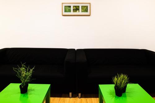 a black couch with two green tables in a living room at Hotel Centro Vitoria AutoCheckIn in Vitoria-Gasteiz