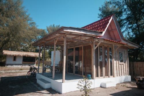 a small house with a wooden roof at Mimpi Bungalow in Gili Meno
