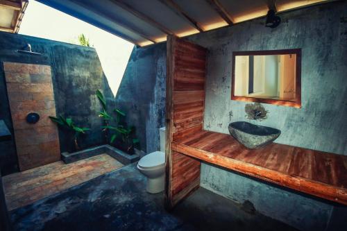 a bathroom with a sink and a toilet and a tub at Mimpi Bungalow in Gili Meno