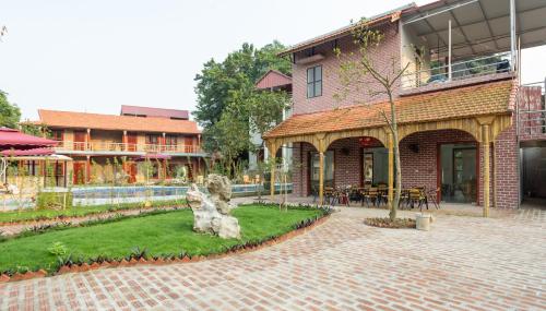 a brick building with a courtyard with a garden at Ruby Homestay in Ninh Binh