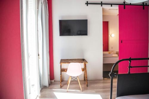 a room with a table and a pink wall at Safestay Madrid Central in Madrid