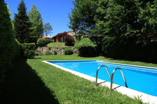 a swimming pool in the yard of a house at Casa de Outeiro in Cabeceiras de Basto