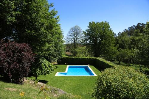 a swimming pool in the middle of a garden at Casa de Outeiro in Cabeceiras de Basto