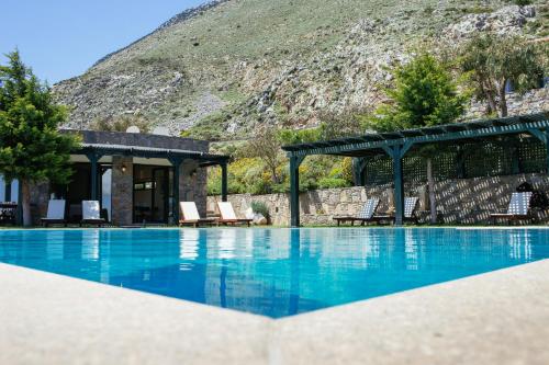 a swimming pool with a mountain in the background at Aetovigla Guesthouse in Krousón
