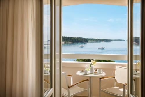 a room with a table and a view of the water at Valamar Riviera Hotel & Residence in Poreč
