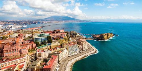 an aerial view of a city next to the ocean at Fiorentini Residence NAPOLI in Naples