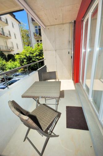 a patio with a table and chairs on a balcony at Stylish 2BR near lake - Flower 3 in Zurich