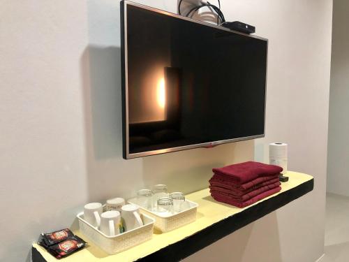 a tv on a shelf in a bathroom with towels at chillchillsangkhlaburi โรงแรมชิลชิลสังขละบุรี in Sangkhla Buri