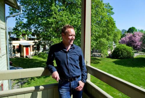 a man standing on the porch of a house at Ronneby Brunnspark Vandrarhem och B&B in Ronneby