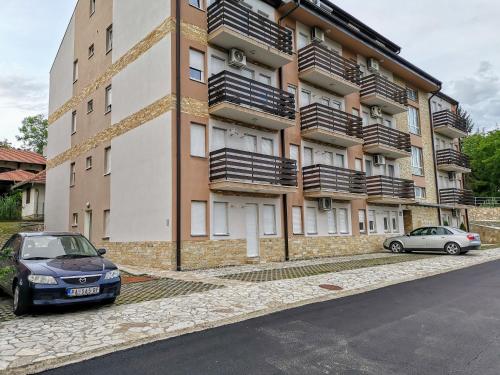 two cars parked in front of a building at Apartman Ljutovac in Gornja Toplica