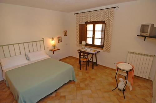 a bedroom with a bed and a table and a window at Agriturismo Podere Micitto in Usi