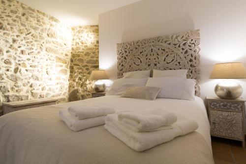 a bedroom with a large white bed with towels on it at Can Martí Sistachrentals in Torroella de Montgrí