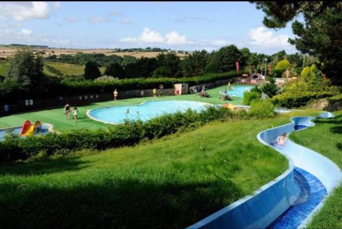 a large swimming pool with people in a park at Luxury Holiday Caravan Home in Newquay