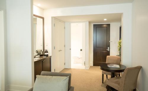 a living room with a table and a chair at Hôtel Le Bonne Entente in Quebec City