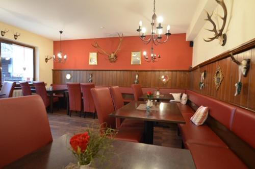 a restaurant with red walls and a table and chairs at Landhotel Christopherhof in Grafenwiesen