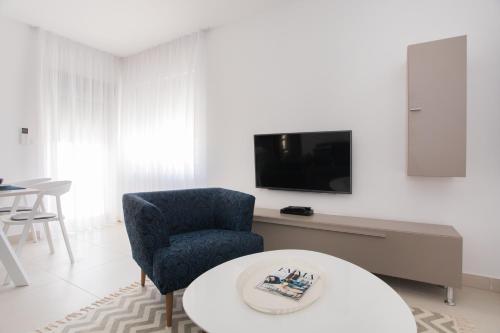 a living room with a blue chair and a tv at blue adria in Primošten